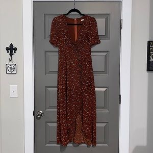 Long, burnt Orange/brick colored dress with flowers. Tortoise shell buttons.